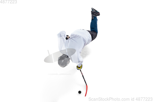 Image of Unrecognizable male hockey player with the stick on ice court and white background