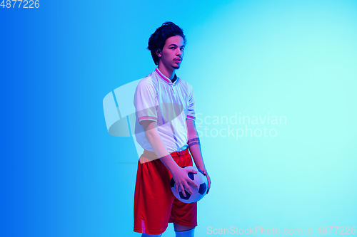 Image of Football or soccer player on gradient background in neon light - motion, action, activity concept