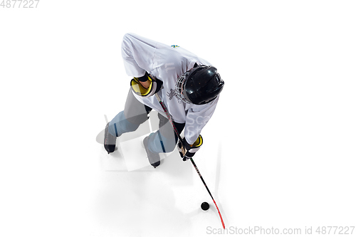 Image of Unrecognizable male hockey player with the stick on ice court and white background