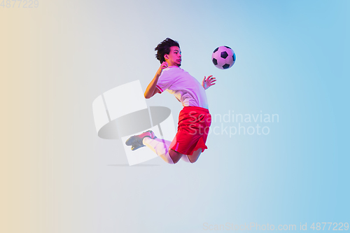 Image of Football or soccer player on gradient background in neon light - motion, action, activity concept