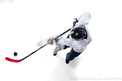 Image of Unrecognizable male hockey player with the stick on ice court and white background