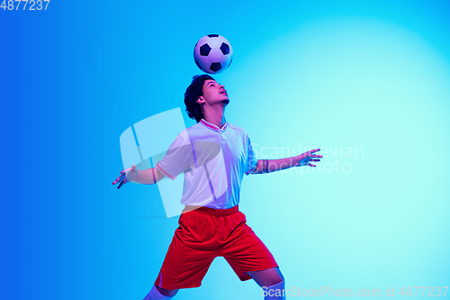 Image of Football or soccer player on gradient background in neon light - motion, action, activity concept