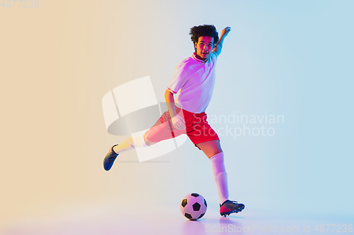 Image of Football or soccer player on gradient background in neon light - motion, action, activity concept