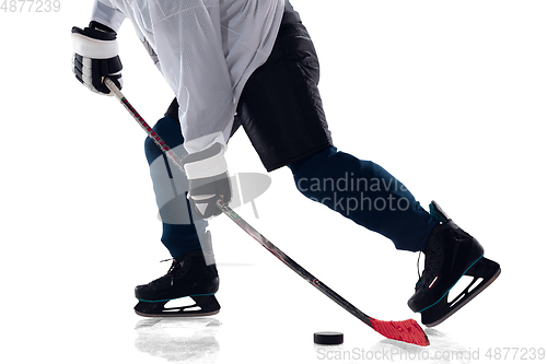 Image of Unrecognizable male hockey player with the stick on ice court and white background