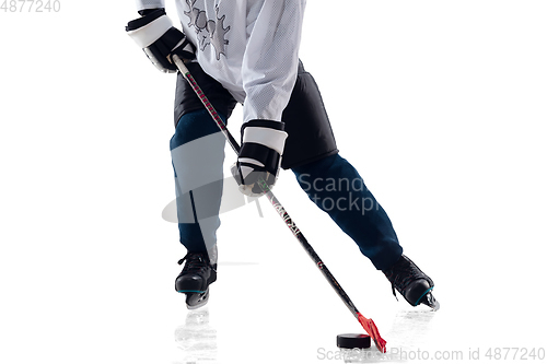 Image of Unrecognizable male hockey player with the stick on ice court and white background