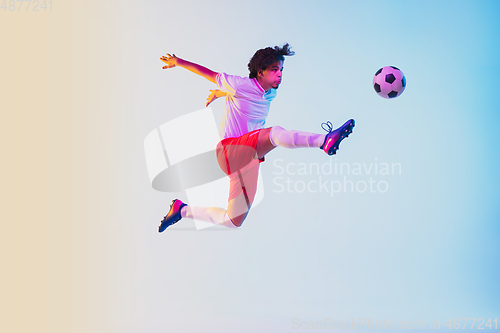 Image of Football or soccer player on gradient background in neon light - motion, action, activity concept
