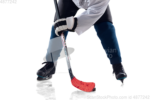 Image of Unrecognizable male hockey player with the stick on ice court and white background