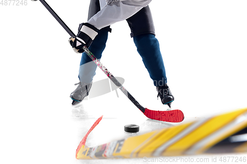 Image of Unrecognizable male hockey player with the stick on ice court and white background