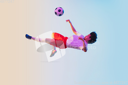 Image of Football or soccer player on gradient background in neon light - motion, action, activity concept