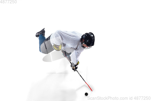 Image of Unrecognizable male hockey player with the stick on ice court and white background