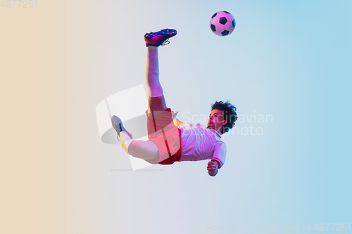 Image of Football or soccer player on gradient background in neon light - motion, action, activity concept