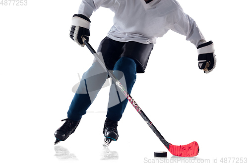 Image of Unrecognizable male hockey player with the stick on ice court and white background