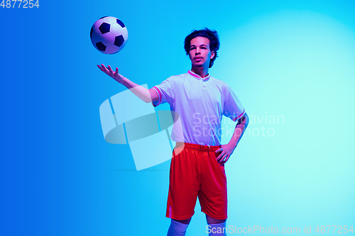 Image of Football or soccer player on gradient background in neon light - motion, action, activity concept