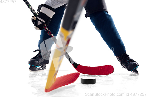 Image of Unrecognizable male hockey player with the stick on ice court and white background