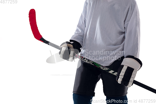 Image of Unrecognizable male hockey player with the stick on ice court and white background