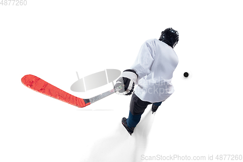 Image of Unrecognizable male hockey player with the stick on ice court and white background