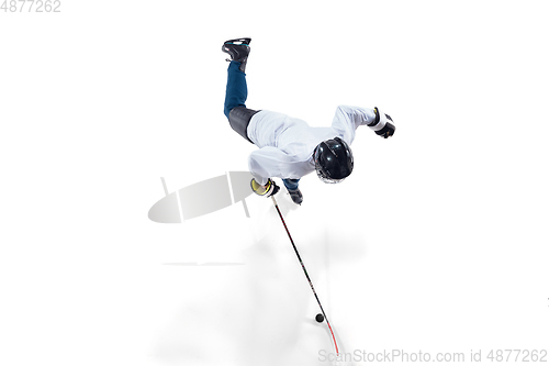 Image of Unrecognizable male hockey player with the stick on ice court and white background