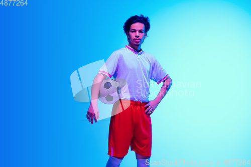 Image of Football or soccer player on gradient background in neon light - motion, action, activity concept