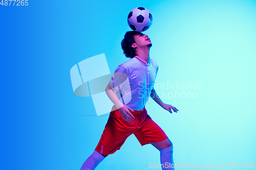 Image of Football or soccer player on gradient background in neon light - motion, action, activity concept