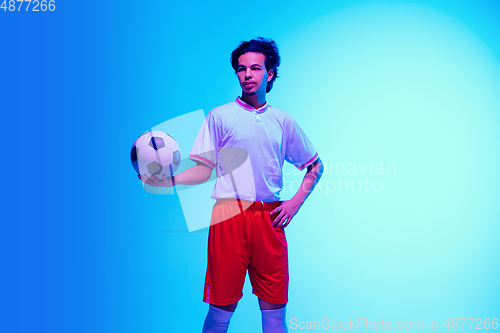 Image of Football or soccer player on gradient background in neon light - motion, action, activity concept