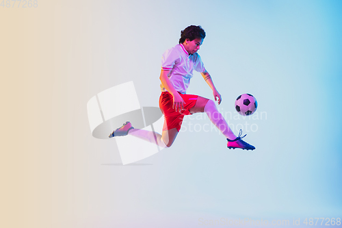 Image of Football or soccer player on gradient background in neon light - motion, action, activity concept