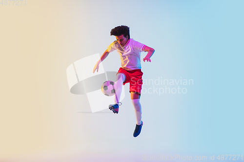 Image of Football or soccer player on gradient background in neon light - motion, action, activity concept