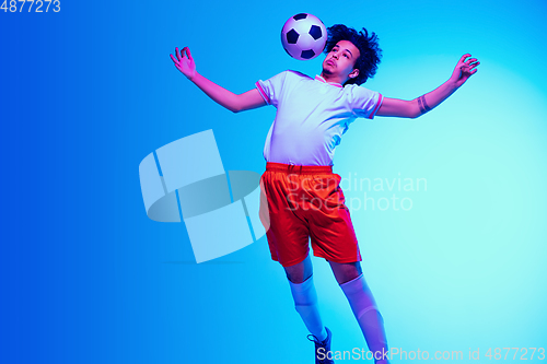 Image of Football or soccer player on gradient background in neon light - motion, action, activity concept