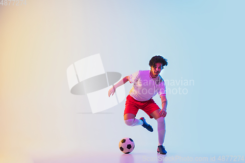 Image of Football or soccer player on gradient background in neon light - motion, action, activity concept