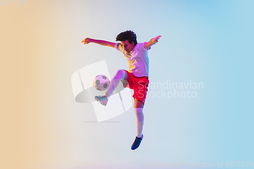 Image of Football or soccer player on gradient background in neon light - motion, action, activity concept