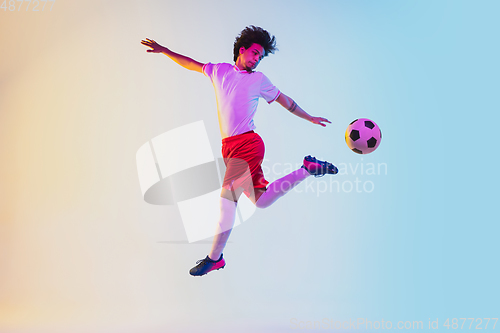 Image of Football or soccer player on gradient background in neon light - motion, action, activity concept