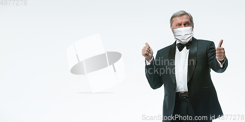 Image of Elegance senior man waiter in protective face mask on white background. Flyer with copyspace.