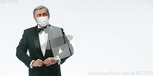 Image of Elegance senior man waiter in protective face mask on white background. Flyer with copyspace.