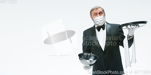 Image of Elegance senior man waiter in protective face mask on white background. Flyer with copyspace.