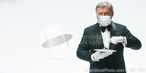 Image of Elegance senior man waiter in protective face mask on white background. Flyer with copyspace.