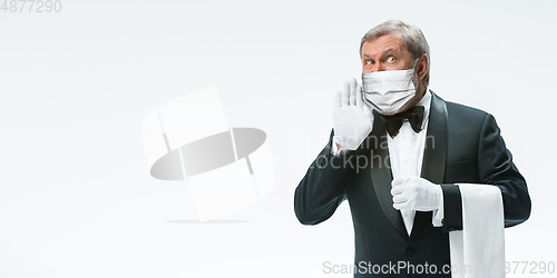 Image of Elegance senior man waiter in protective face mask on white background. Flyer with copyspace.