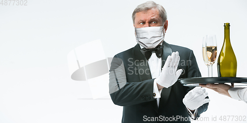 Image of Elegance senior man waiter in protective face mask on white background. Flyer with copyspace.