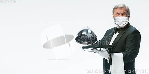 Image of Elegance senior man waiter in protective face mask on white background. Flyer with copyspace.