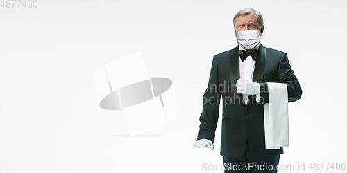 Image of Elegance senior man waiter in protective face mask on white background. Flyer with copyspace.