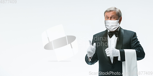 Image of Elegance senior man waiter in protective face mask on white background. Flyer with copyspace.