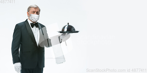 Image of Elegance senior man waiter in protective face mask on white background. Flyer with copyspace.