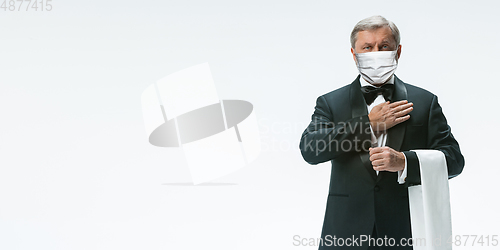 Image of Elegance senior man waiter in protective face mask on white background. Flyer with copyspace.