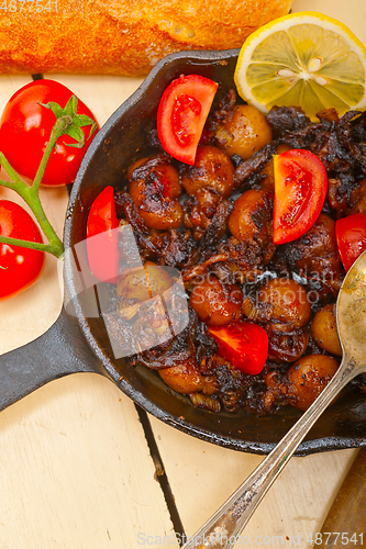 Image of Baby cuttle fish roasted on iron skillet