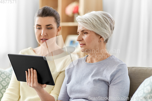 Image of daughter and senior mother with tablet pc at home