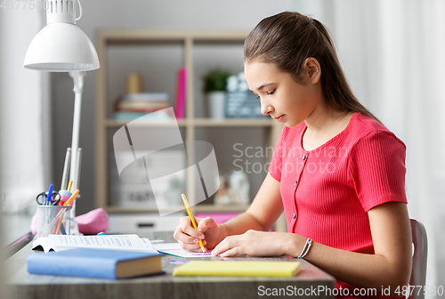 Image of student girl with ruler drawing line in notebook