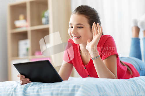 Image of girl having vide call on tablet computer at home