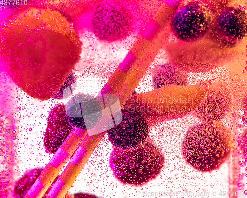 Image of Close up view of the cold and fresh lemonade with bright berries in neon light