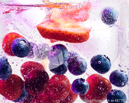 Image of Close up view of the cold and fresh lemonade with bright berries in neon light