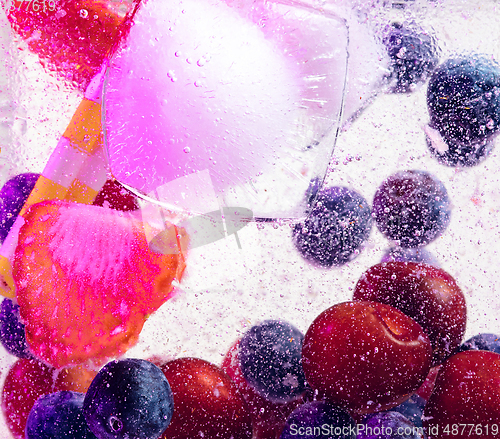 Image of Close up view of the cold and fresh lemonade with bright berries in neon light