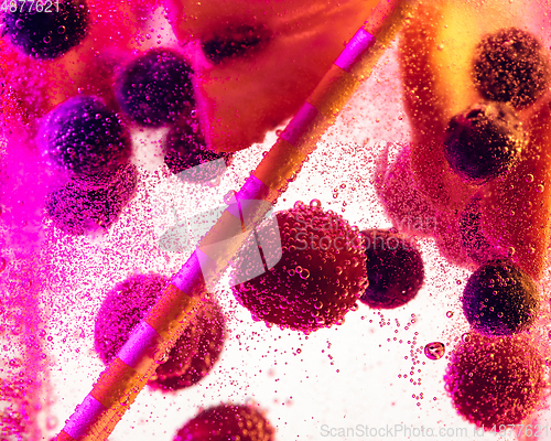 Image of Close up view of the cold and fresh lemonade with bright berries in neon light