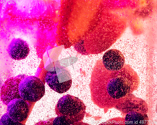 Image of Close up view of the cold and fresh lemonade with bright berries in neon light